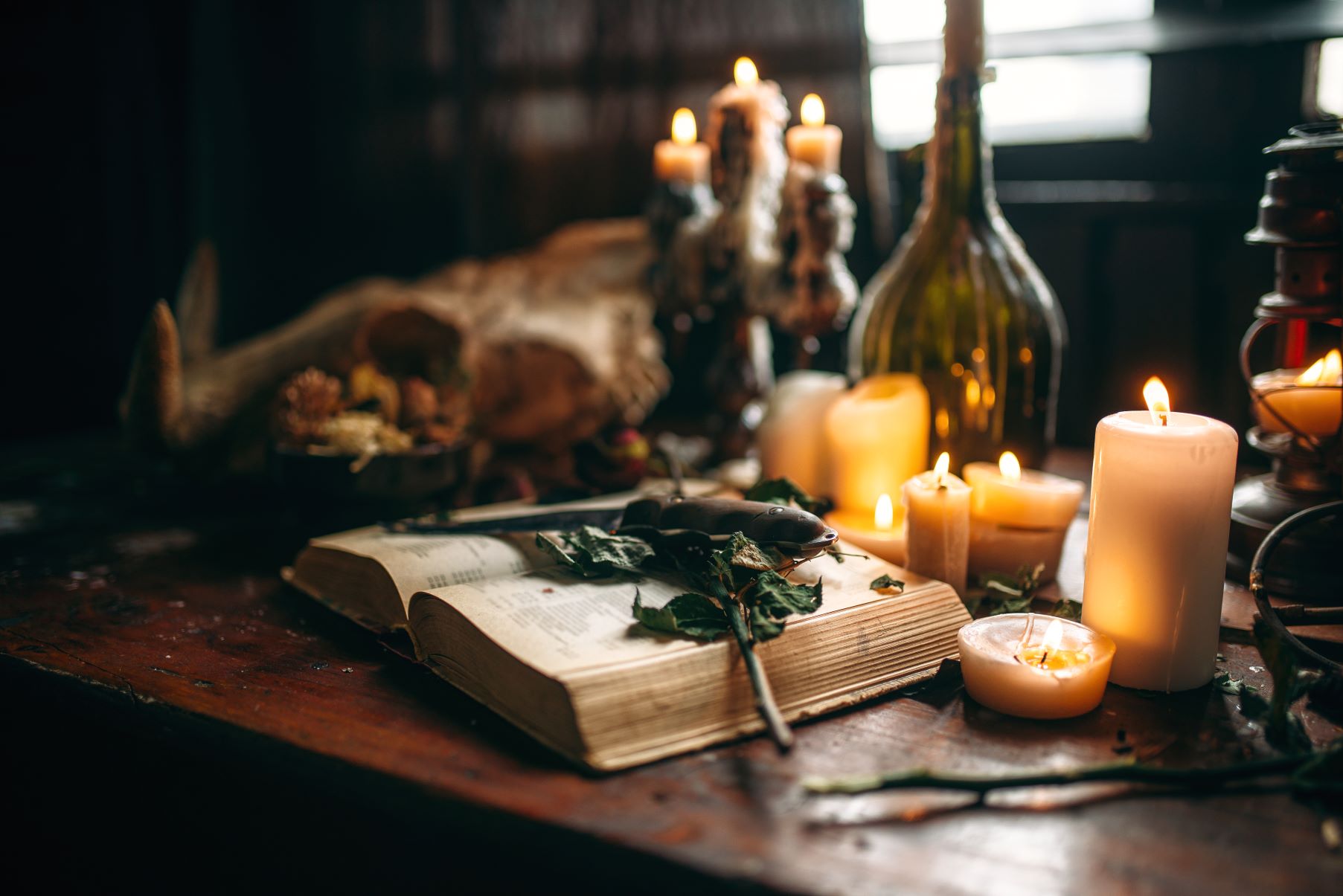 Open book and candles in a dark mystical setting for modern witchcraft practice